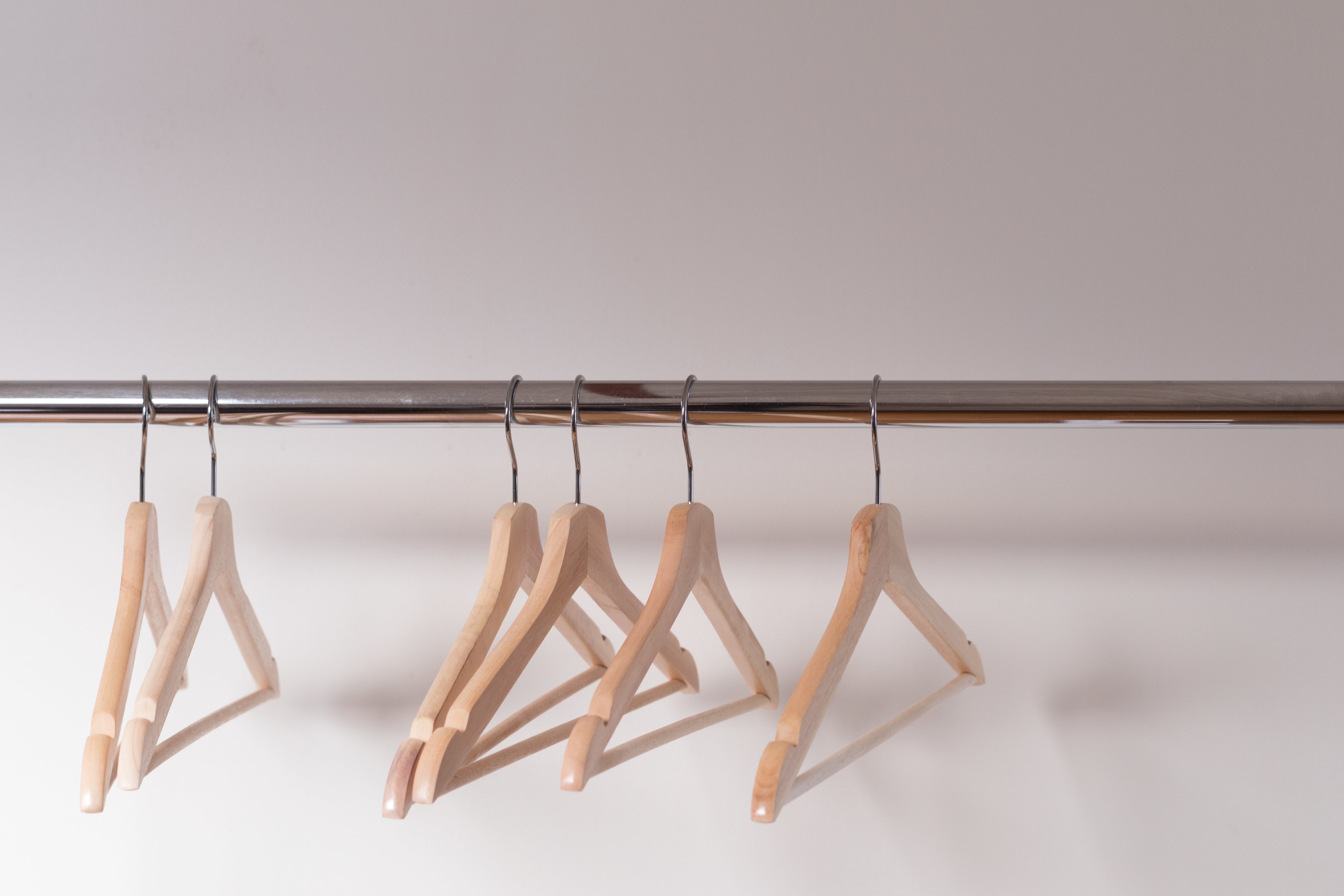 wooden-clothes-hangers-cling-emptily-to-the-shiny-shop-rack.jpg